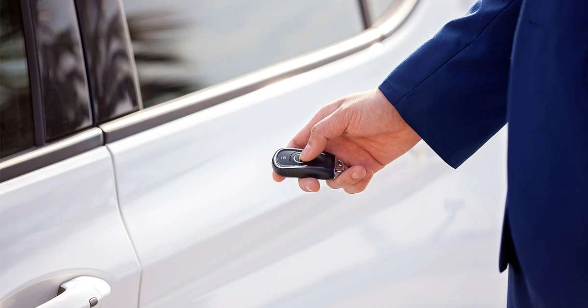 1200x628a-hand-holding-a-car-key-fob-next-to-a-vehicle